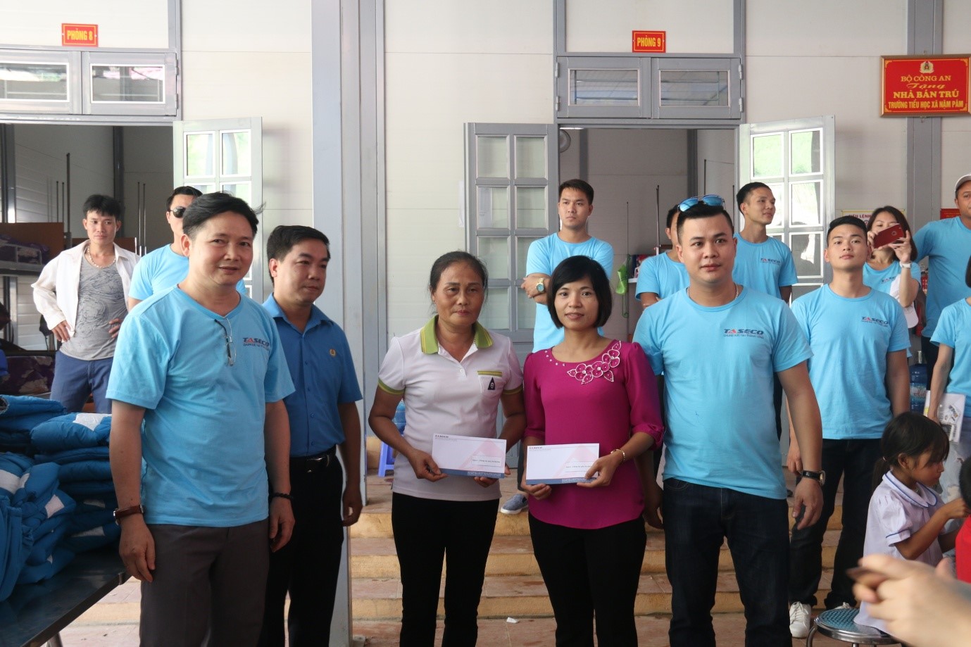 Ông Nguyễn Quang Huy (bên trái) – Đại diện công ty TASECO trao tặng quà cho cán bộ quản lý Nhà bán trú trường tiểu học xã Nặm Păm