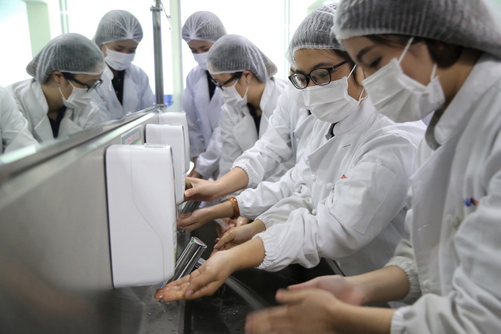 Các bạn sinh viên chuẩn bị quần áo bảo hộ và vệ sinh tay trước khi thăm quan quy trình sản xuất suất ăn hàng không